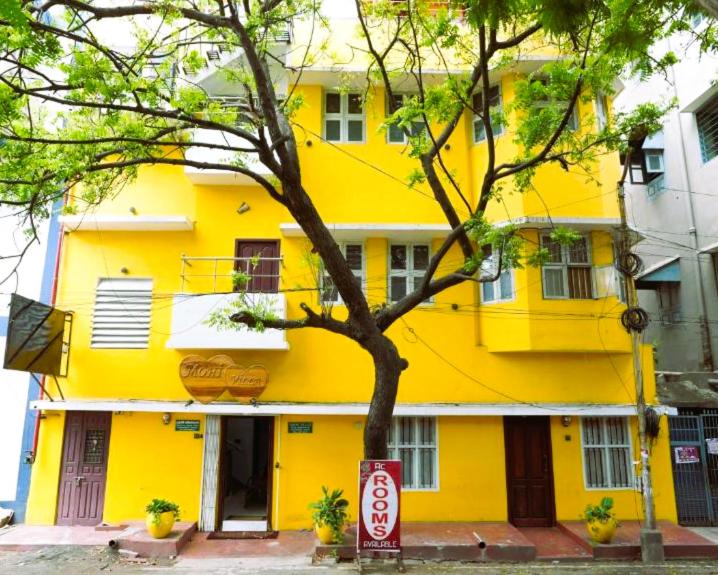 a yellow building with a sign in front of it at MOHI VILLA in Pondicherry