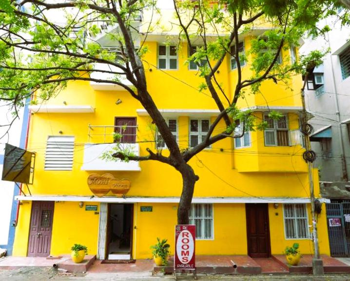 Un edificio amarillo con un cartel delante. en MOHI VILLA, en Pondicherry