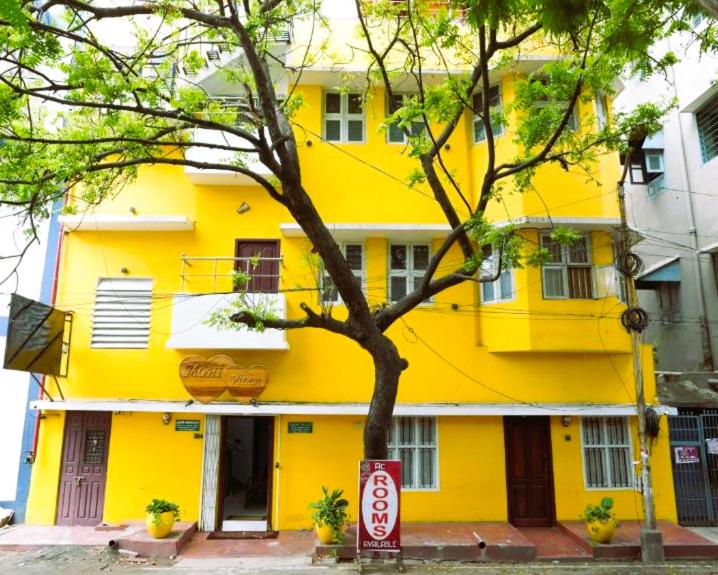 a yellow building with a sign in front of it at MOHI VILLA in Puducherry