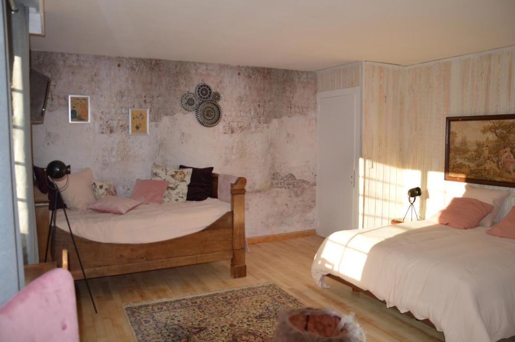1 dormitorio con 2 camas y sofá en Moulin de la Cuse - Chambre l'Anse, en Cusance