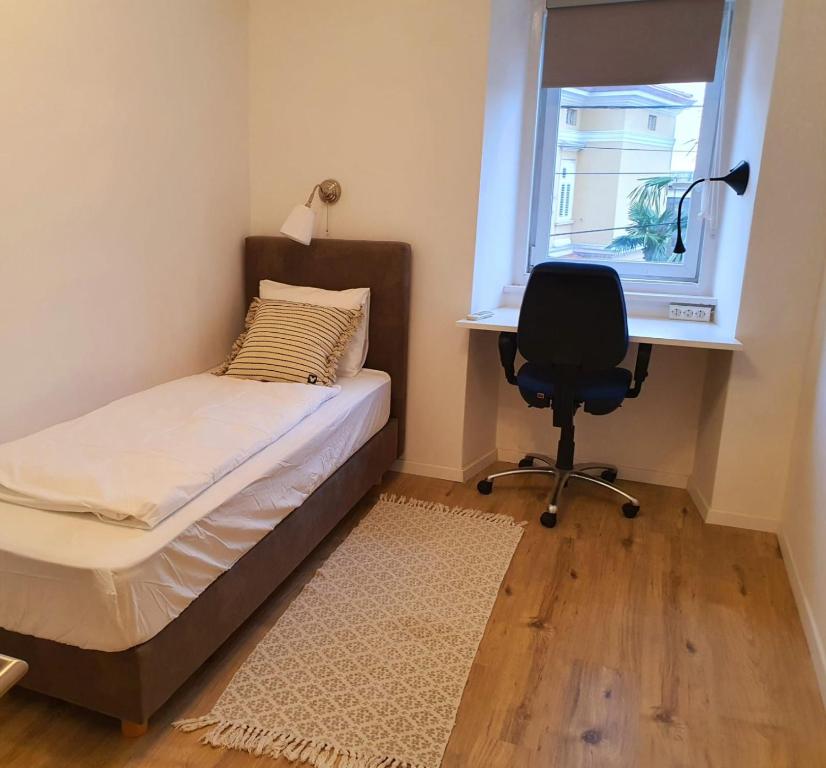 a bedroom with a bed and a desk and a chair at Nice 2 bedroom apartment near city center in Rijeka