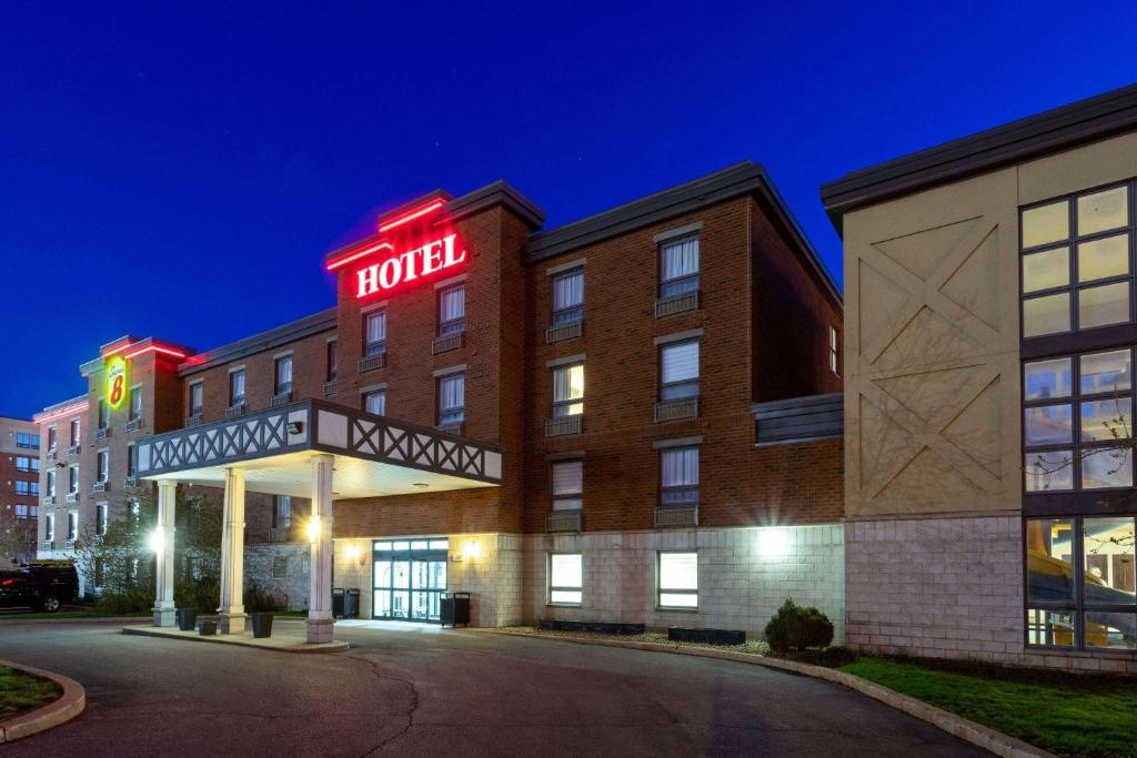 a hotel with a sign on the front of a building at Super 8 by Wyndham Lachenaie/Terrebonne in Terrebonne