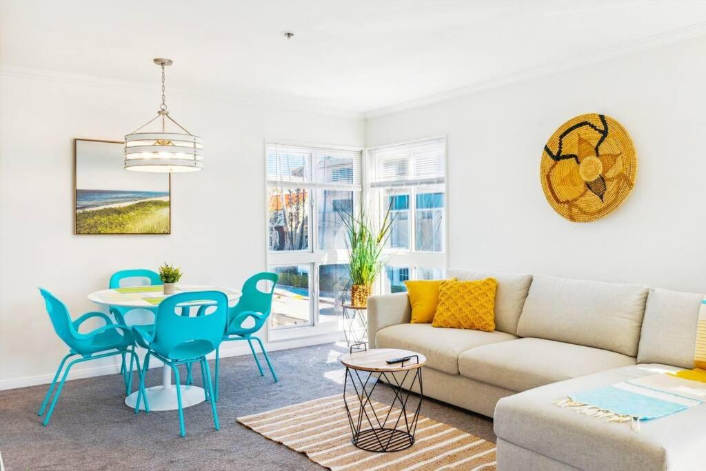 Una sala de estar con un sofá, una mesa y sillas. en Seas the Day by Cardo - La Jolla Beachfront, en San Diego