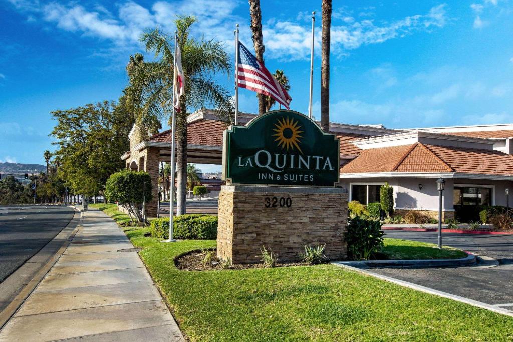 a sign for a la quinta inn and suites at La Quinta by Wyndham Pomona in Pomona