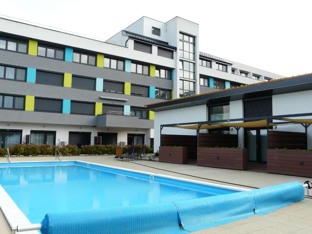 a large swimming pool in front of a building at Juventus Meggie in Balatonföldvár