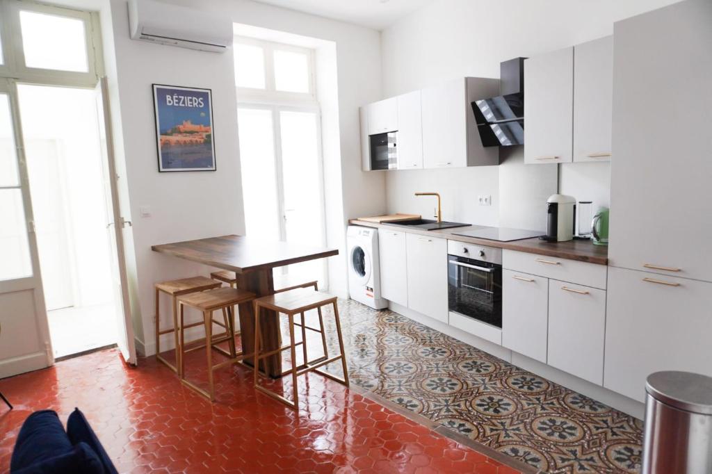 eine Küche mit weißen Schränken und einem Holztisch in der Unterkunft Beautiful apartments & Loft in Beziers center in Béziers