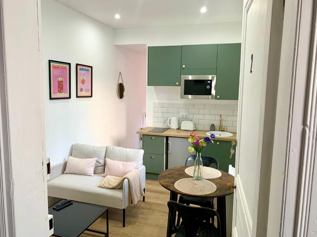 un petit salon avec un canapé et une table dans l'établissement La maison des trois mâts, à Rochefort