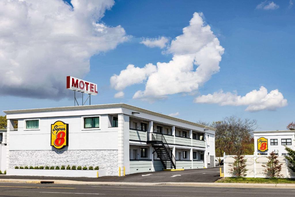 a motel sign on the top of a building at Super 8 by Wyndham Lindenhurst 