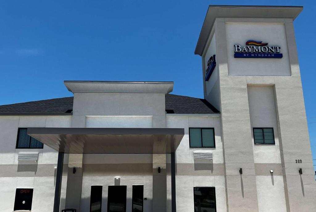 a front view of a building with a sign on it at Baymont by Wyndham Freeport Texas in Freeport