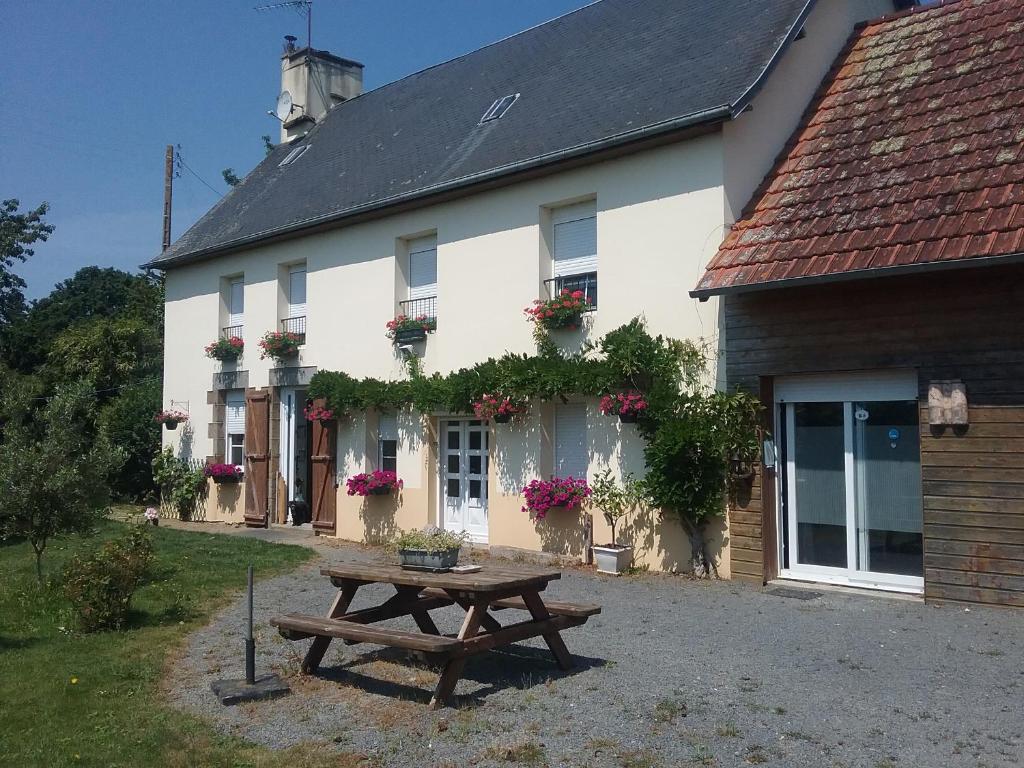 ein Haus mit einem Picknicktisch davor in der Unterkunft Au Sourire des Jeunes in Brécey