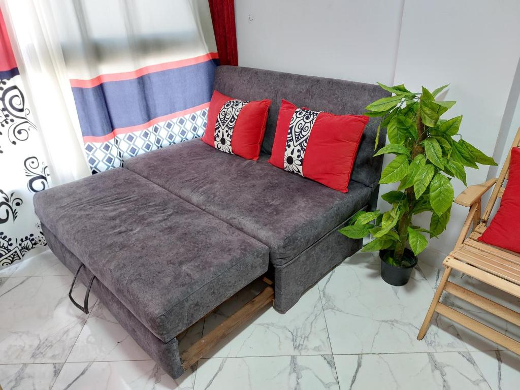 ein Sofa mit Kissen darauf im Wohnzimmer in der Unterkunft بورتو سعيد - Porto Said in `Ezbet Shalabi el-Rûdi