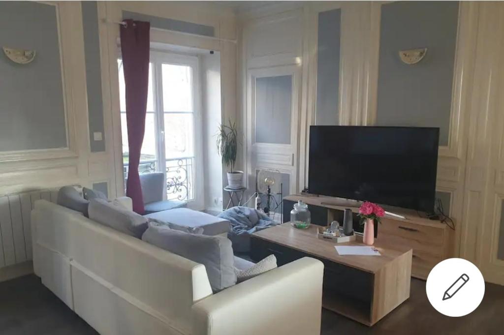 un salon avec un canapé et une télévision dans l'établissement Appartement idéal en centre ville, à Pont-Audemer
