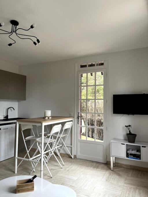 une cuisine avec un comptoir, une table et une fenêtre dans l'établissement Cozy flat, quiet retreat w/ queen bed near forest, à Barbizon