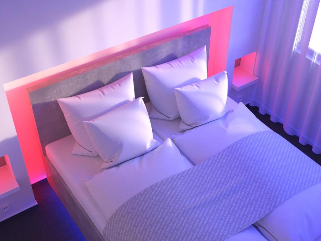 a bedroom with a bed with white pillows at smartel at The Unbrexit in Ahaus