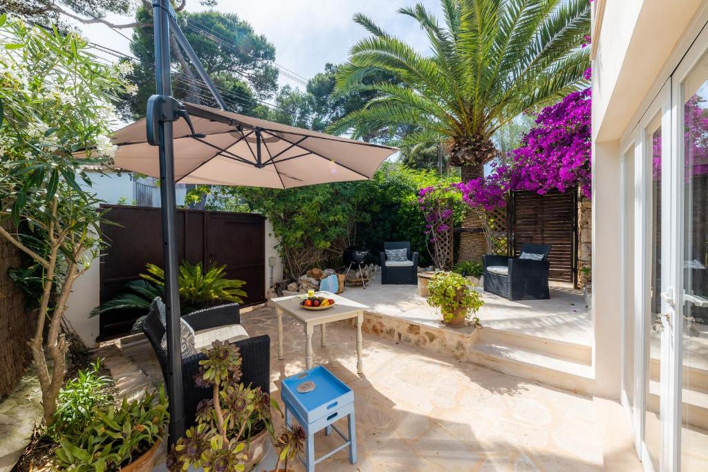 une terrasse avec une table et un parasol dans l'établissement Cel Pins, à Portopetro