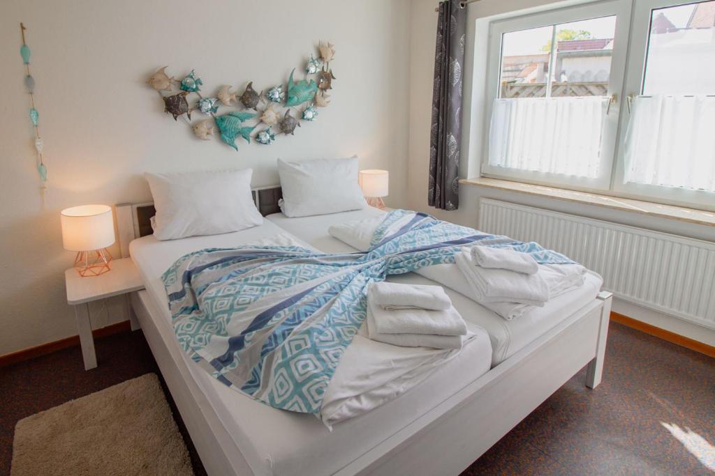 1 cama blanca con edredón y almohadas en Leybuchthus Stina, en Krummhörn
