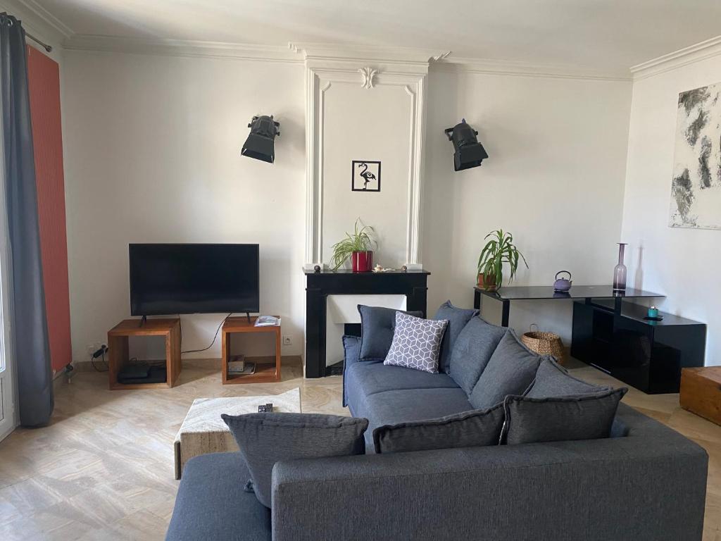 uma sala de estar com um sofá e uma televisão em Nid douillet t3 au coeur des remparts em Aigues-Mortes