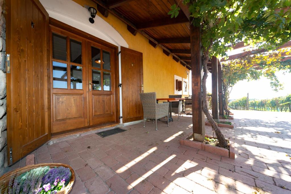 une terrasse couverte d'une maison avec une grande porte en bois dans l'établissement Tagyon Birtok Hordó Apartman, à Tagyon