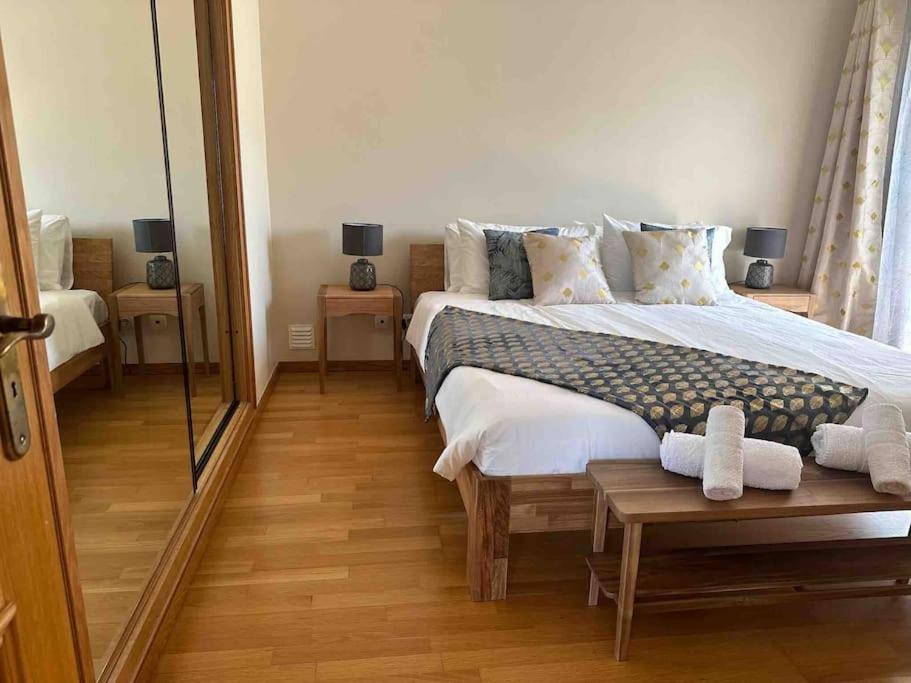1 dormitorio con 1 cama grande y espejo en Casa Amália, en Estômbar