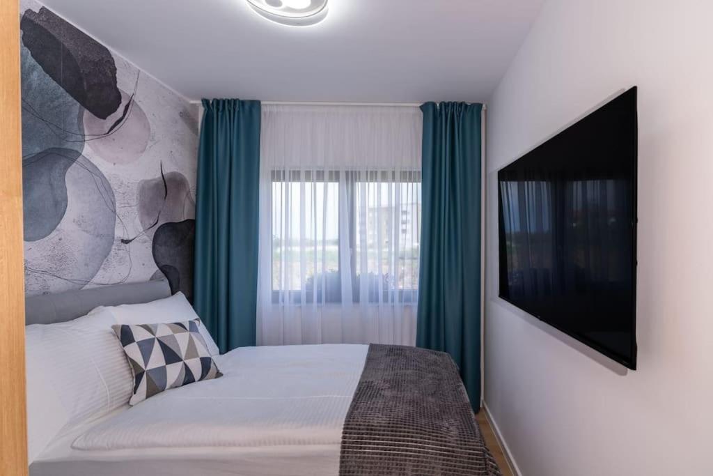 a bedroom with a bed and a flat screen tv at Capsula Luxury Apartment Umag in Umag