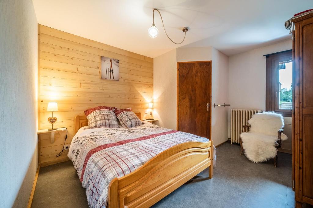 a bedroom with a bed with a wooden wall at Coeur de Charmy - 10 personnes in Abondance