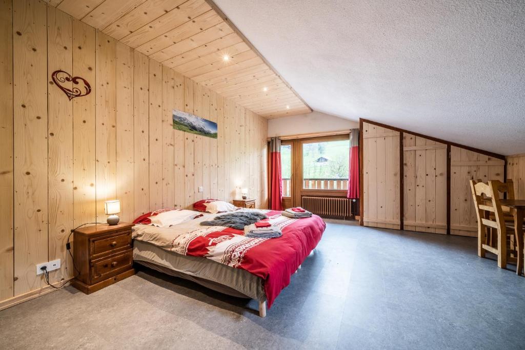 a bedroom with a bed and a wooden wall at Coeur de Charmy - 10 personnes in Abondance