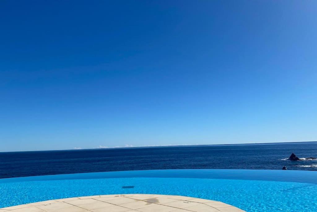 a swimming pool with the ocean in the background at Appart vue mer avec piscine in Saint-Raphaël