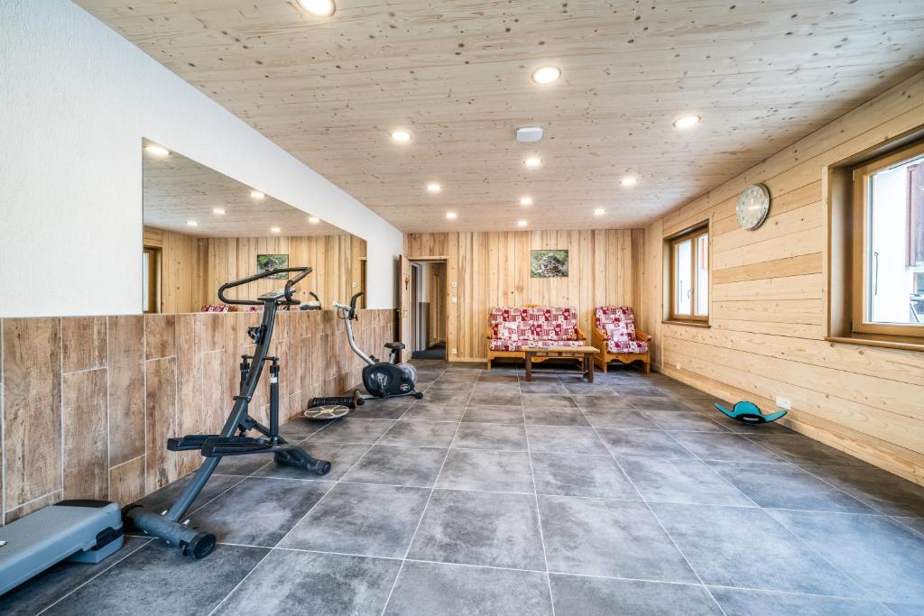 a room with a gym with a treadmill and chairs at Coeur de Charmy - 10 personnes in Abondance