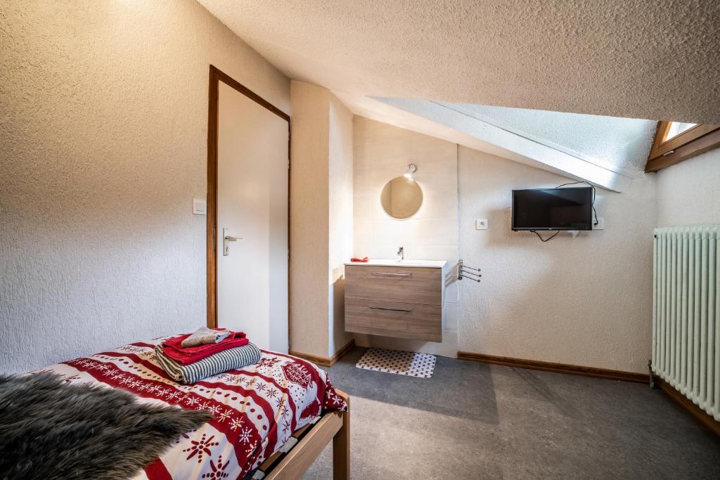 a bedroom with a bed and a sink and a mirror at Coeur de Charmy - 10 personnes in Abondance