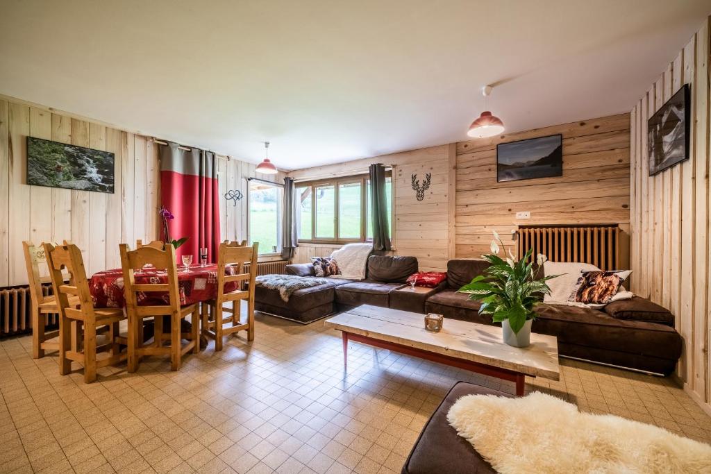 a living room with a couch and a table at Coeur de Charmy - 10 personnes in Abondance