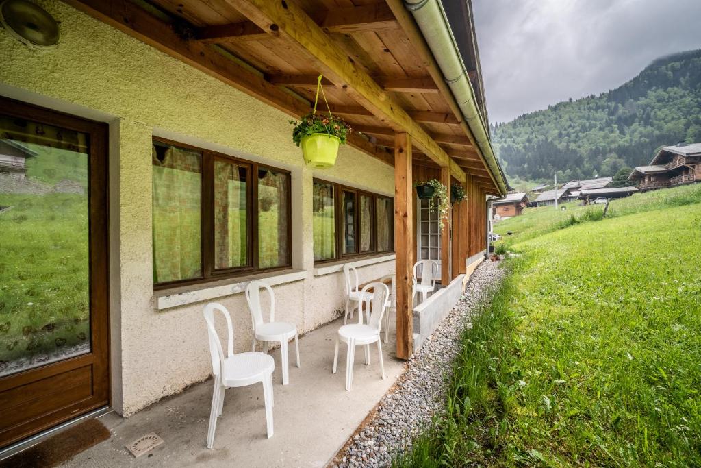 a porch of a house with chairs and a table at Coeur de Charmy - 10 personnes in Abondance