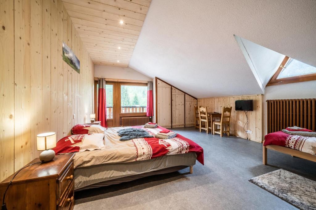 a bedroom with a large bed in a room with wooden walls at Coeur de Charmy - 10 personnes in Abondance