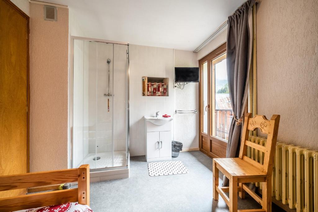 a bathroom with a shower and a sink and a chair at Coeur de Charmy - 10 personnes in Abondance