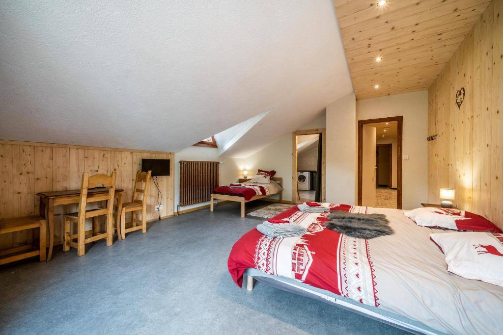 a bedroom with a bed and a desk in a room at Coeur de Charmy - 10 personnes in Abondance