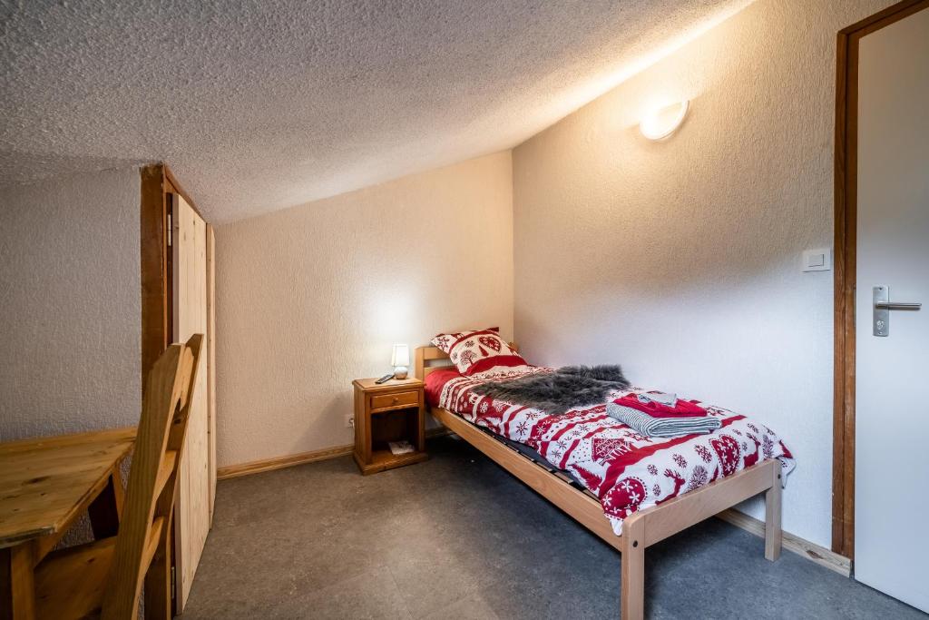 a small bedroom with a bed and a night stand at Coeur de Charmy - 10 personnes in Abondance