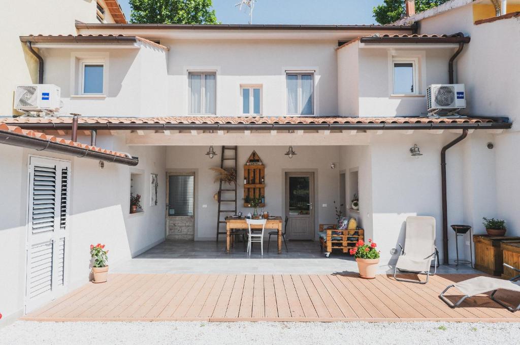 a white house with a patio and a table at Nonna Gina Country House in San Miniato Basso
