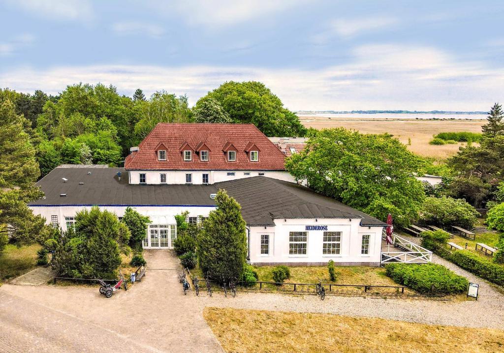 eine Luftansicht eines weißen Hauses mit rotem Dach in der Unterkunft Hotel Heiderose Hiddensee in Neuendorf