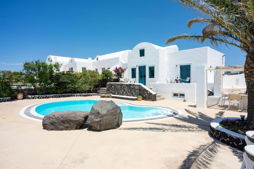 - une piscine en face d'une villa blanche dans l'établissement Villa Oinos - Sunset Views, à Órmos Athiniós