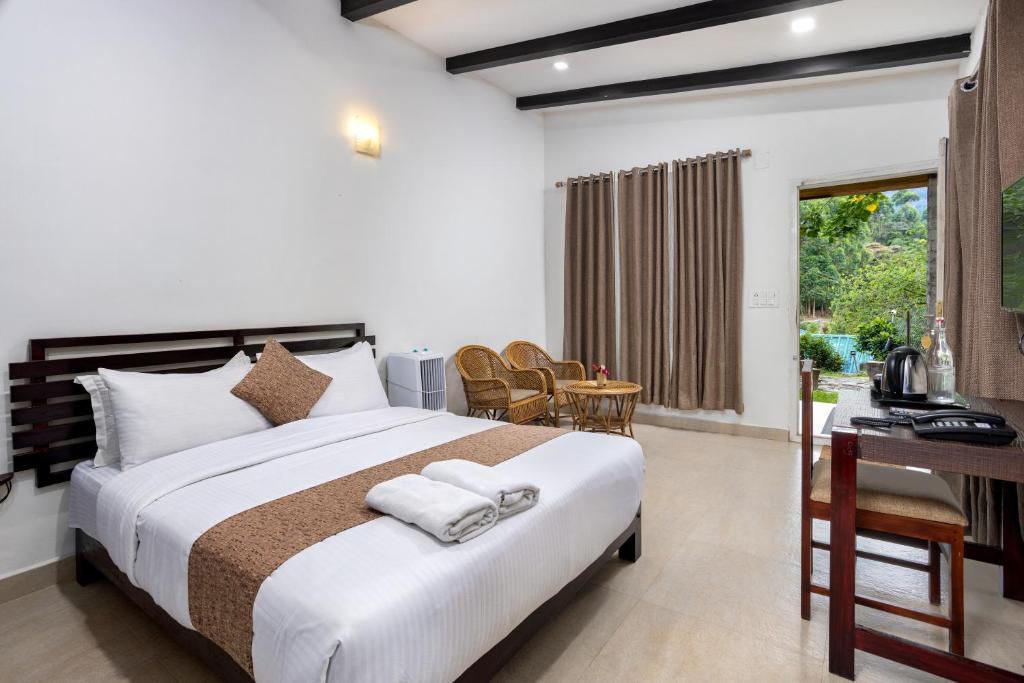 a bedroom with a large bed with a desk and a table at Nexstay Ministers Mansion in Kanthalloor