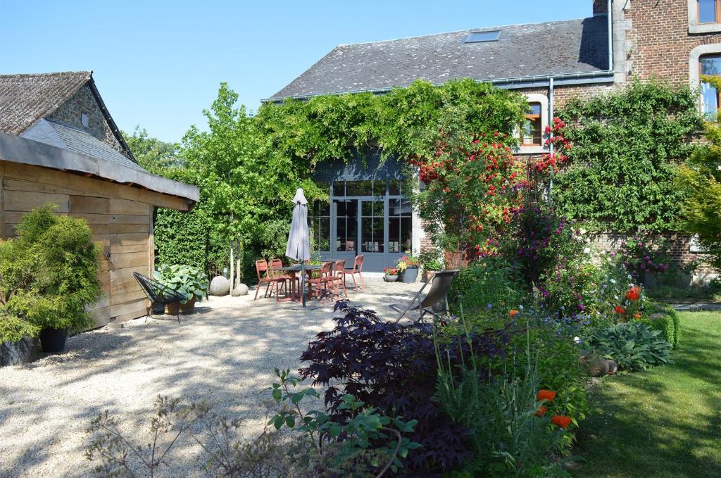 a house with a patio with a table and chairs at La Jardinière in Érezée