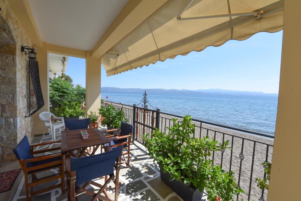 a balcony with a table and chairs and the ocean at Jeannet's Beach House in Amarynthos