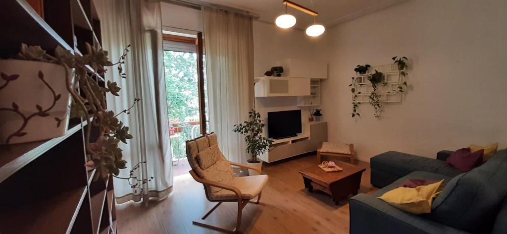 een woonkamer met een blauwe bank en een tv bij Appartamento Viale Puccini - Free Gated Parking - 3 Minutes from Center in Lucca