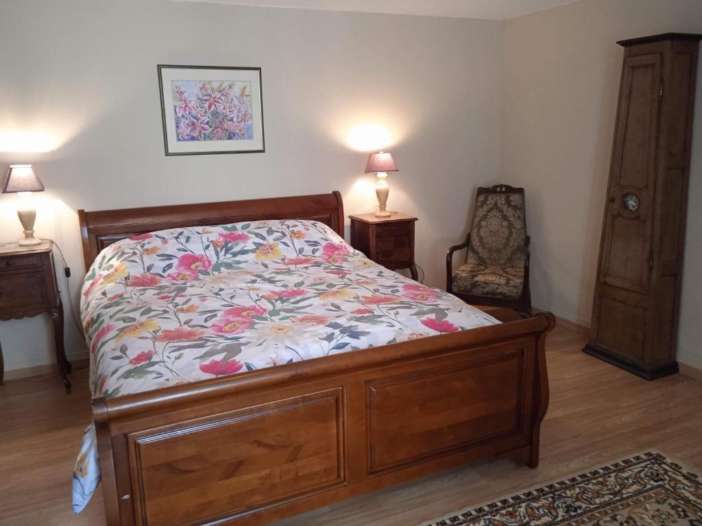 a bedroom with a bed and a chair and two lamps at Charming detached 2 bedroom ancient house in medieval quarter of a small town in the Pays de la Loire, France in Sillé-le-Guillaume