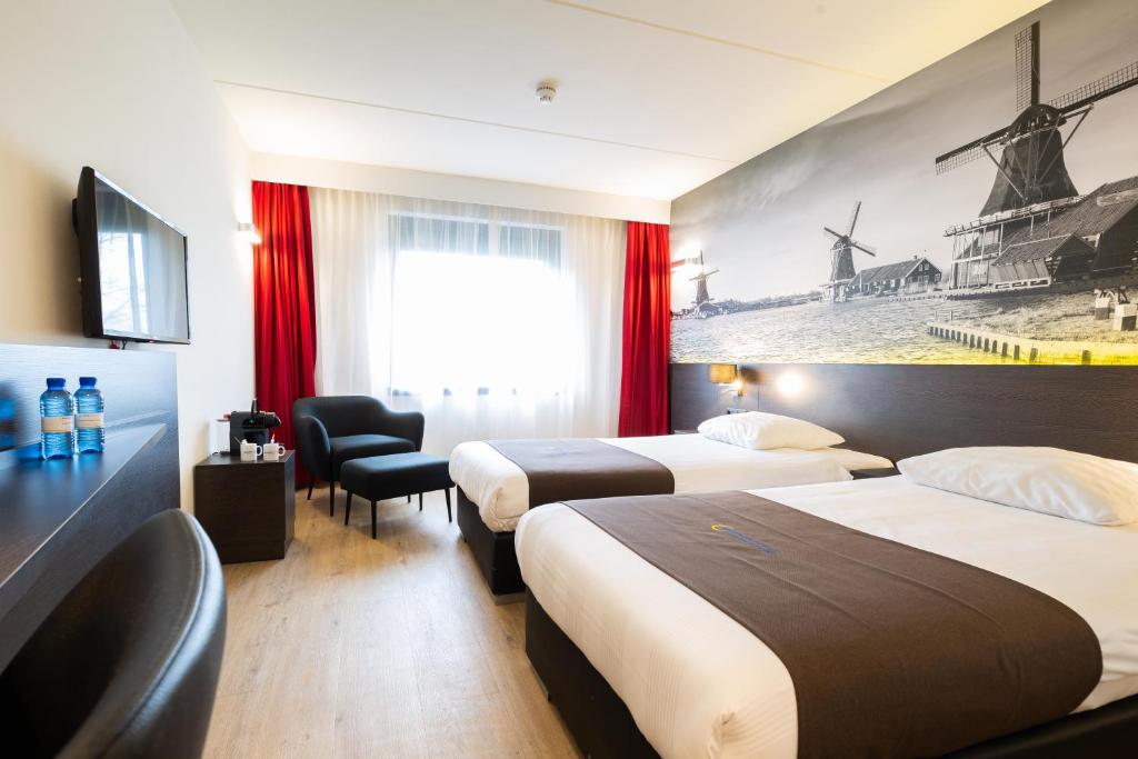 a hotel room with two beds and a tv at Bastion Hotel Zaandam in Zaandam