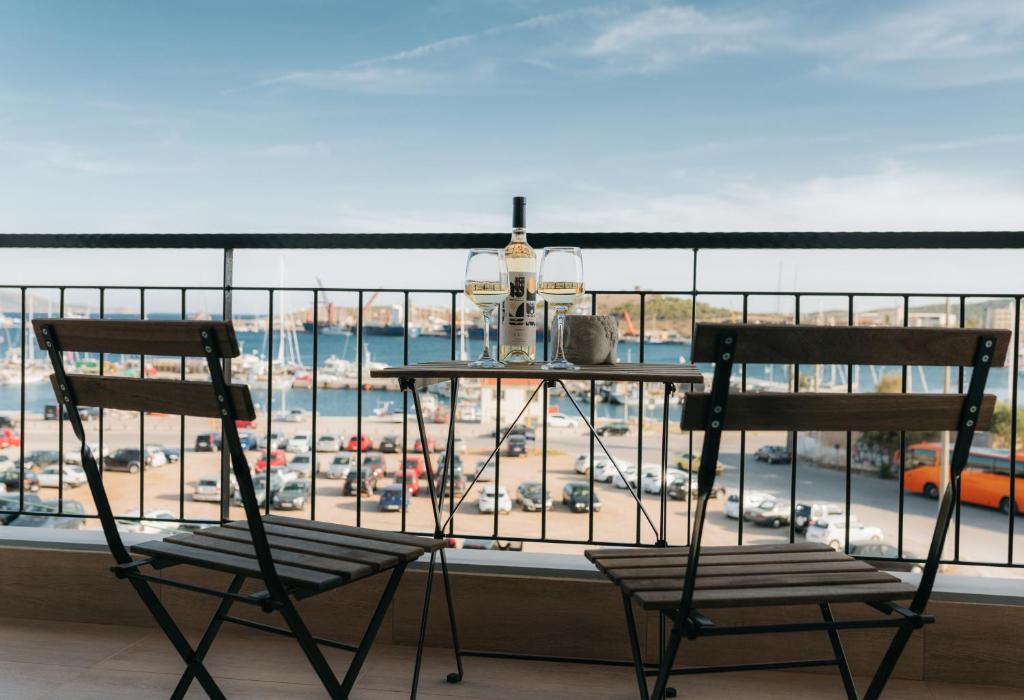 two chairs on a balcony with a view of a parking lot at Luxury Port View in Lavrio
