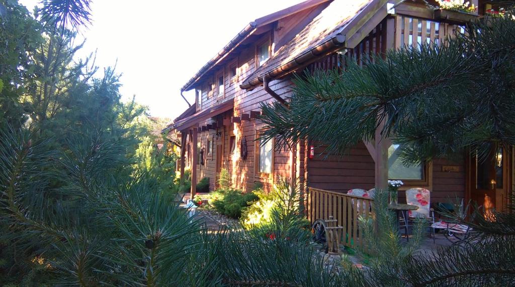 a wooden house with trees and plants in front of it at OW Gabi in Mrzeżyno
