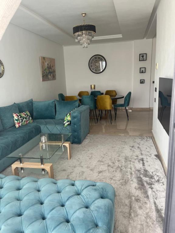 uma sala de estar com um sofá azul e uma mesa em Agadir Bay 2 em Agadir