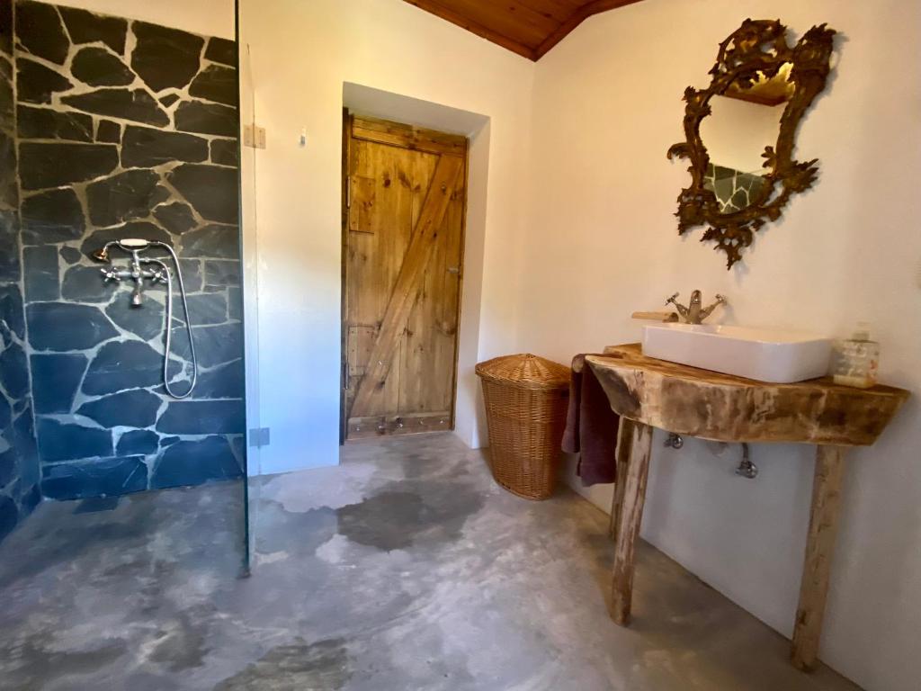 a bathroom with a sink and a stone wall at Casa do Baloiço in Janeiro de Baixo