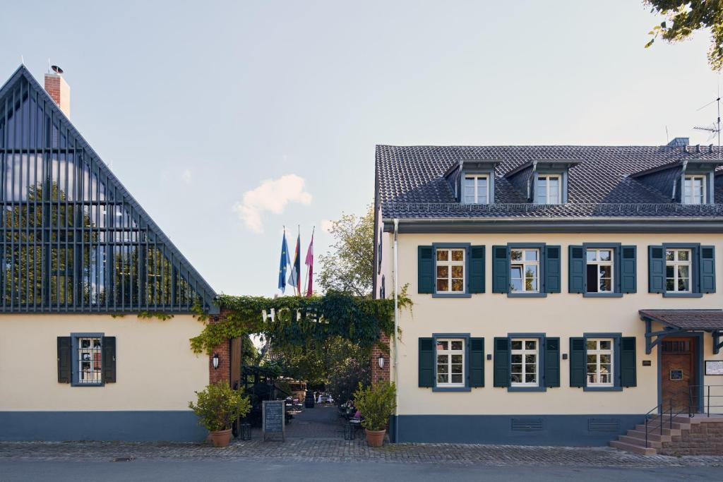 ein großes weißes Gebäude mit grünen Rollläden in der Unterkunft Hotel & Restaurant Grenzhof in Heidelberg