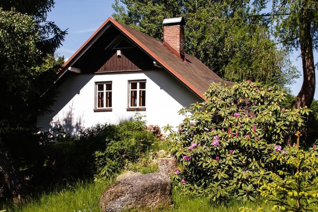 una pequeña casa blanca con techo rojo en Chata Sedmidomí, en Lučany nad Nisou